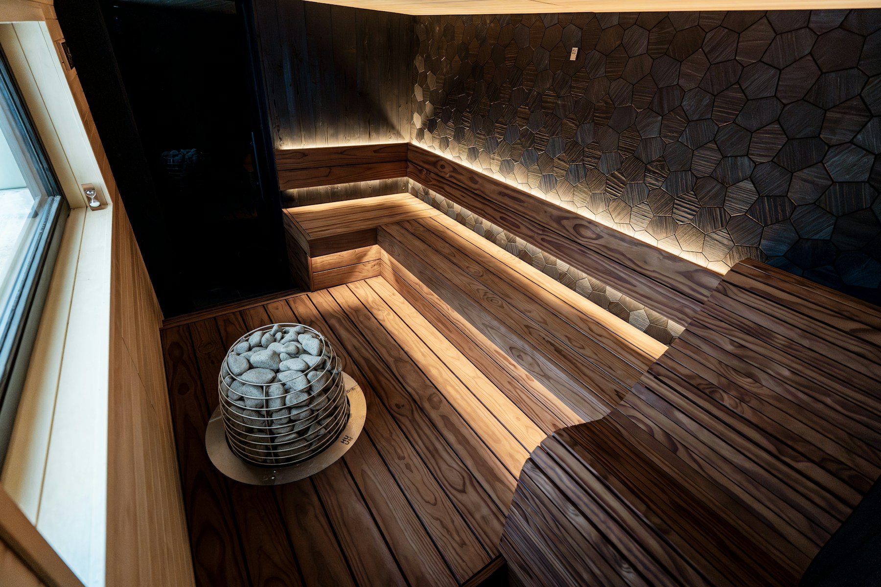 A cedar room of steam, stone heater at the floor