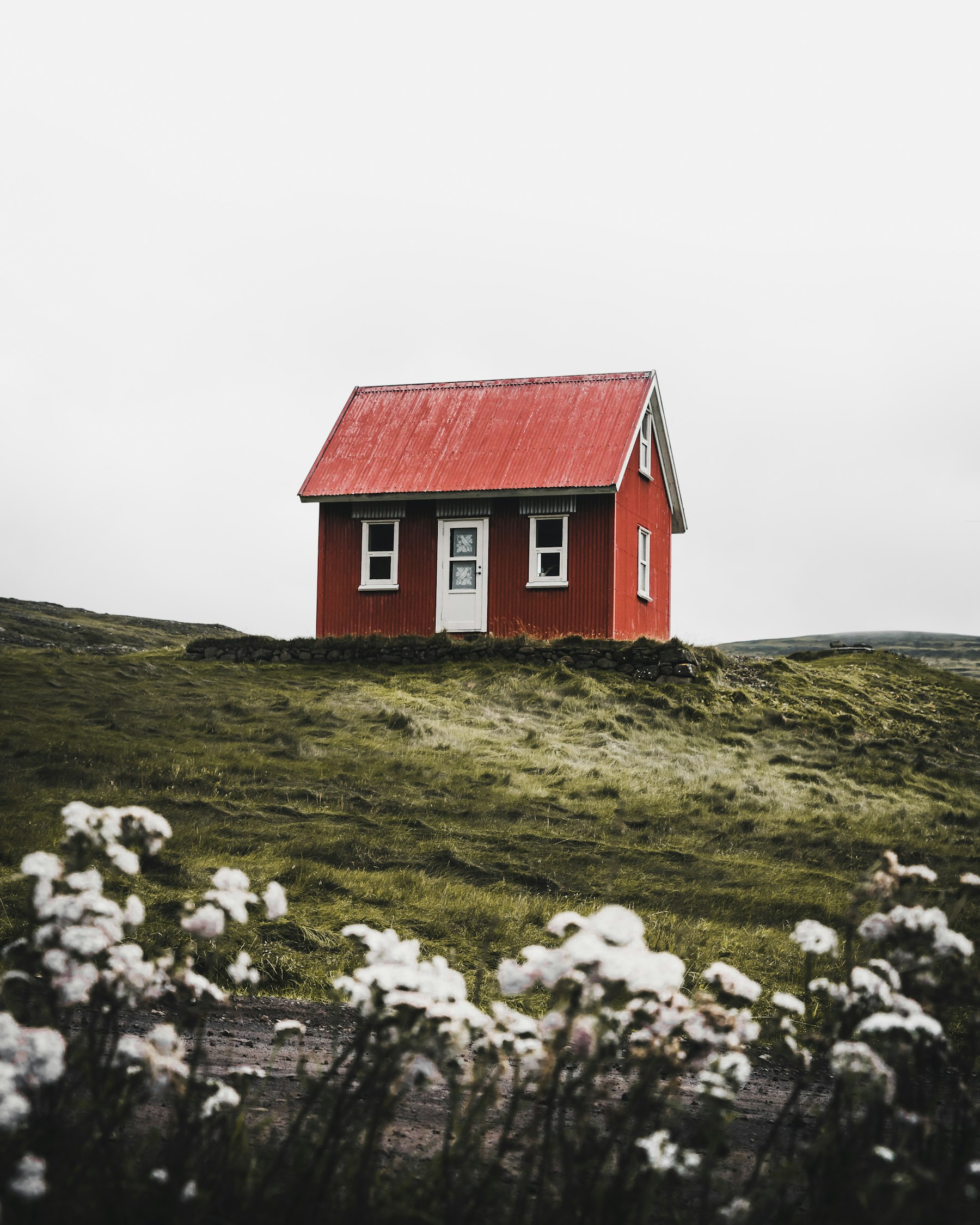 A small red cottage on a grassy rise